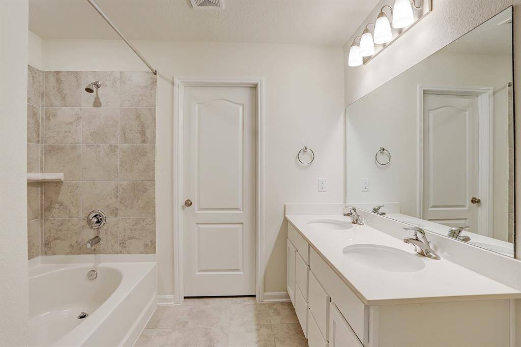 Tiled master bath with double sinks.