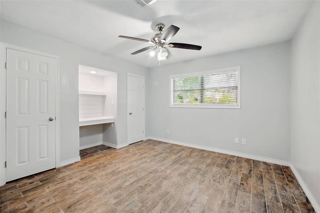 Light-filled and versatile, the secondary bedroom offers a custom desk nook with shelving, a ceiling fan, and flexible layouts to fit your needs.