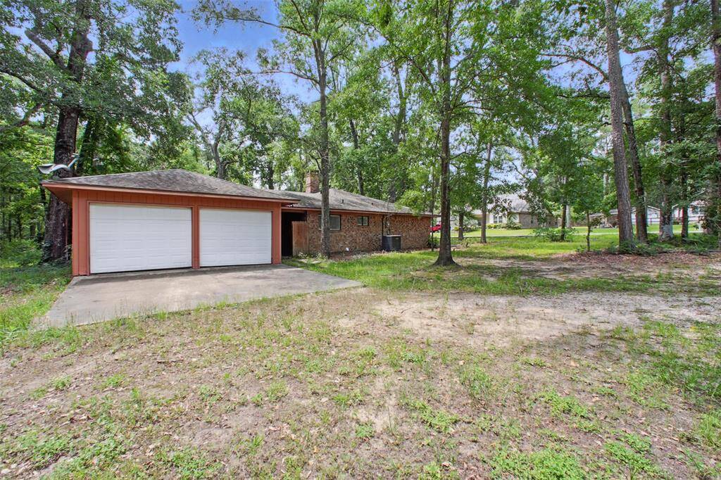 The detached two-car garage and double-wide driveway provide functional charm, while the red brick exterior offers enduring curb appeal.