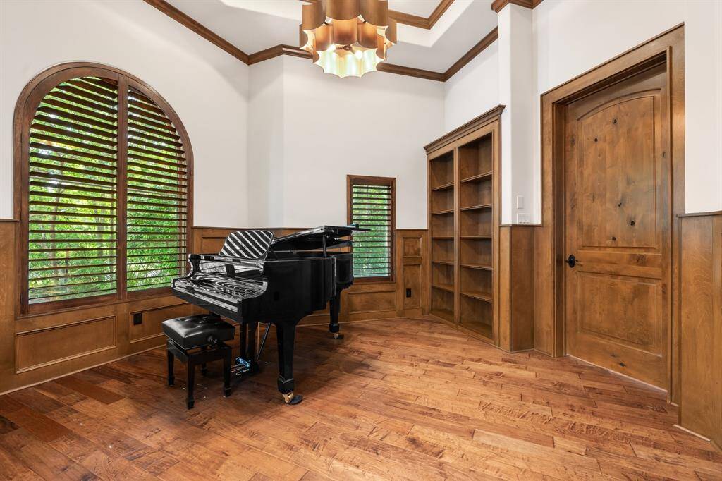 A handsome study features built-in storage, plantation shutters and eye-catching designer fixture.