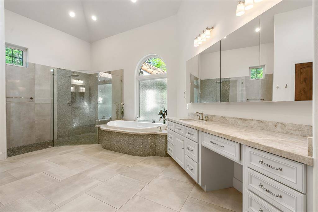 Beautifully remodeled, the primary bath offers generous storage with quartzite counters, updated tile surrounds, new toilet, hardware, sink, lighting and flooring!