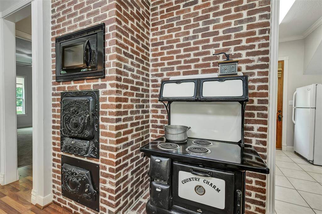 Cast iron Antique styled built-in oven and Cast Iron Stove!!! We love the timeless brick accents in this home!
