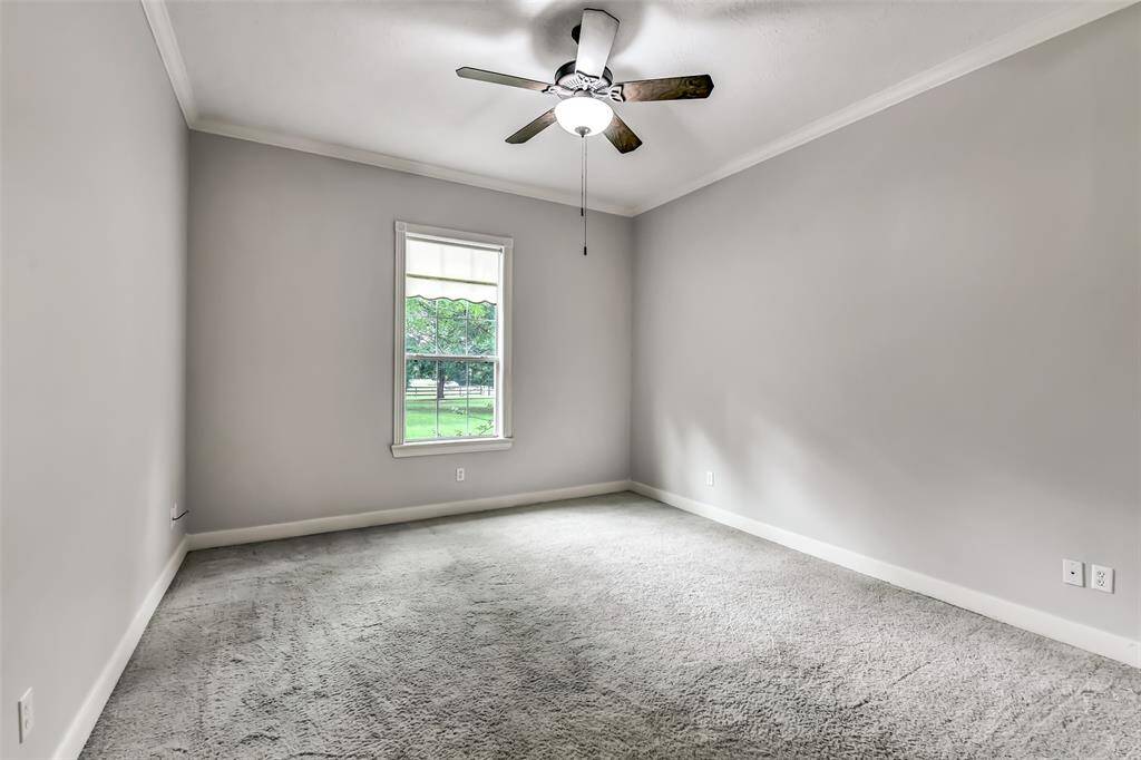 Secondary bedroom has its own private bath. Features 2025 paint, crown molding, ceiling fan and plenty of space.