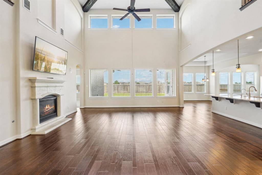 Flooded with natural light, the living areas feel welcoming and homey. Notice the beamed ceiling and art niches.