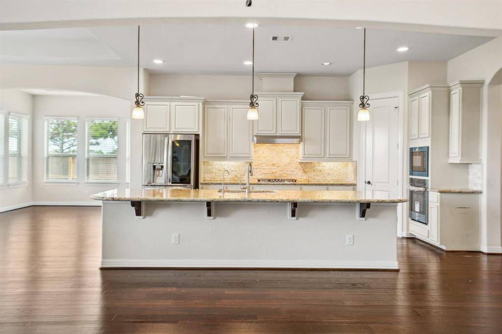 Kitchen glows with warmth. Luxury smart fridge and new microwave/oven await. 5-burner gas grill with plenty of prep space on either side. Pull out drawers and large pantry.