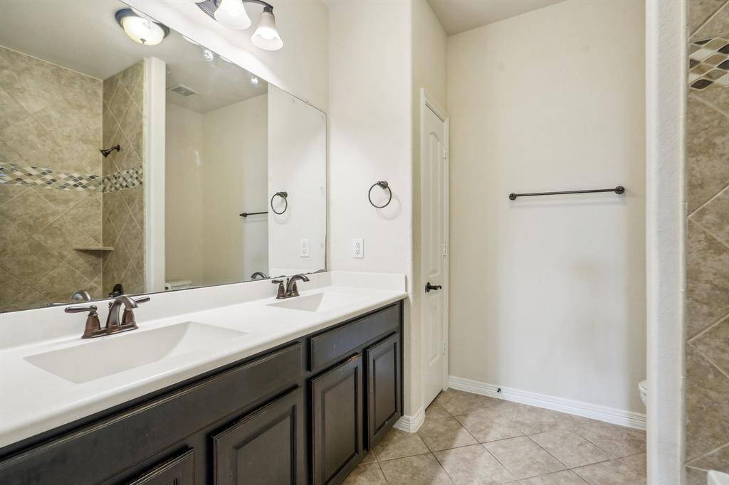 Secondary bath upstairs features double sinks and spacious countertops.