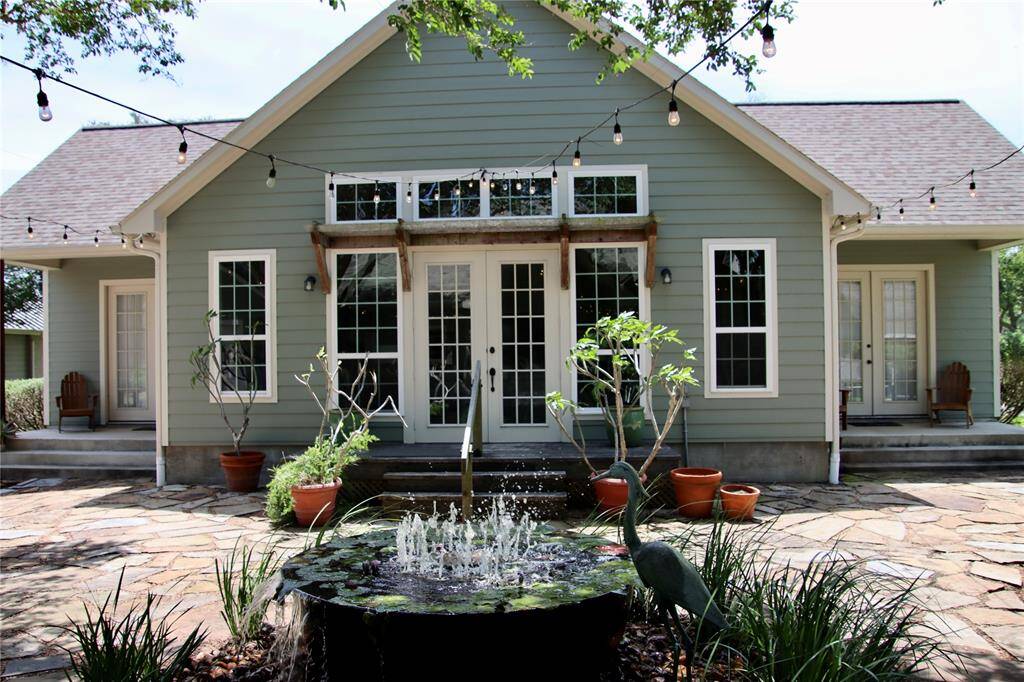 French doors and cafe lights invite you into a thoughtfully designed patio—perfect for outdoor dinners or unwinding at golden hour.