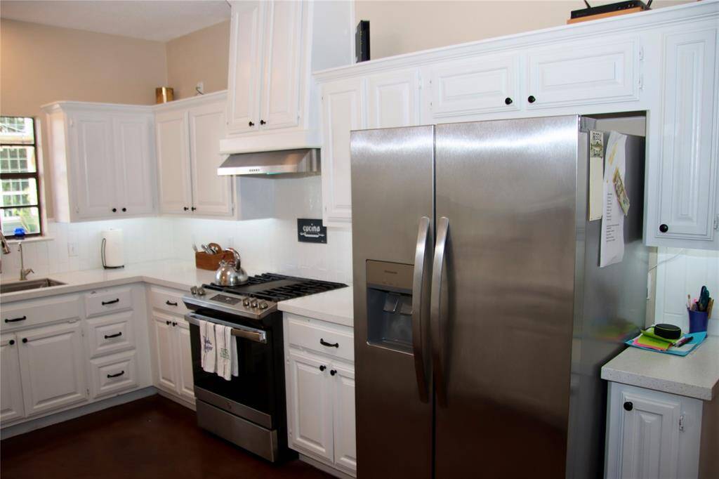Classic and crisp, this kitchen features bright white cabinetry, stainless steel appliances, and generous prep space for the home chef.