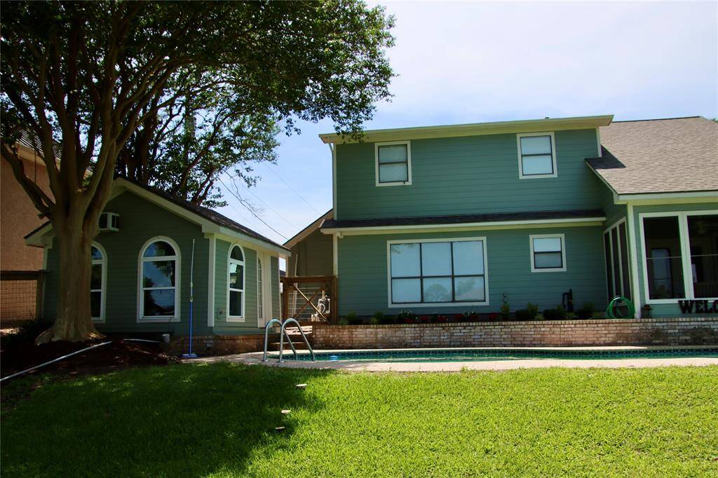 Poolside comfort meets guesthouse charm in this private corner of the backyard, framed by trees and fresh landscaping.