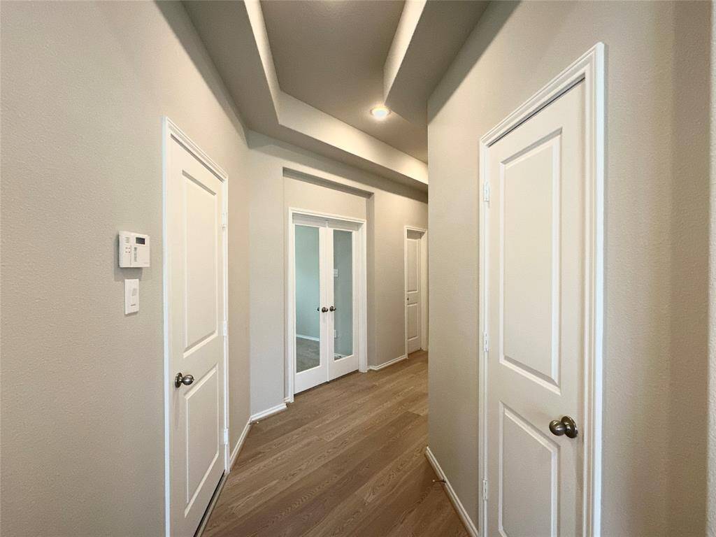 The view from the entryway of the foyer the elegant French doors leading the office.