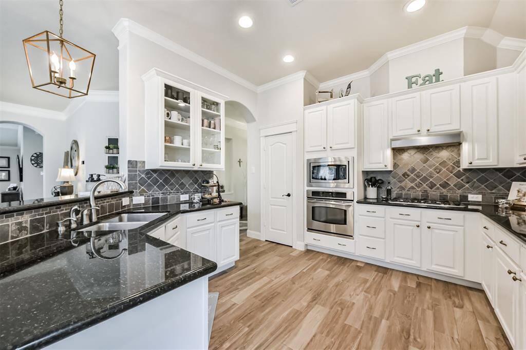 A kitchen featuring a double stainless steel undermount sink and ample counter space, perfect for food preparation..