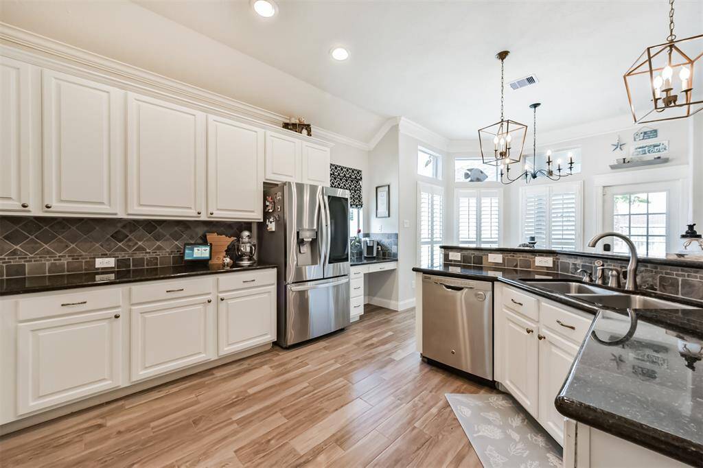 Tall cabinets adorned with elegant crown molding, paired with a functional chef's desk.
