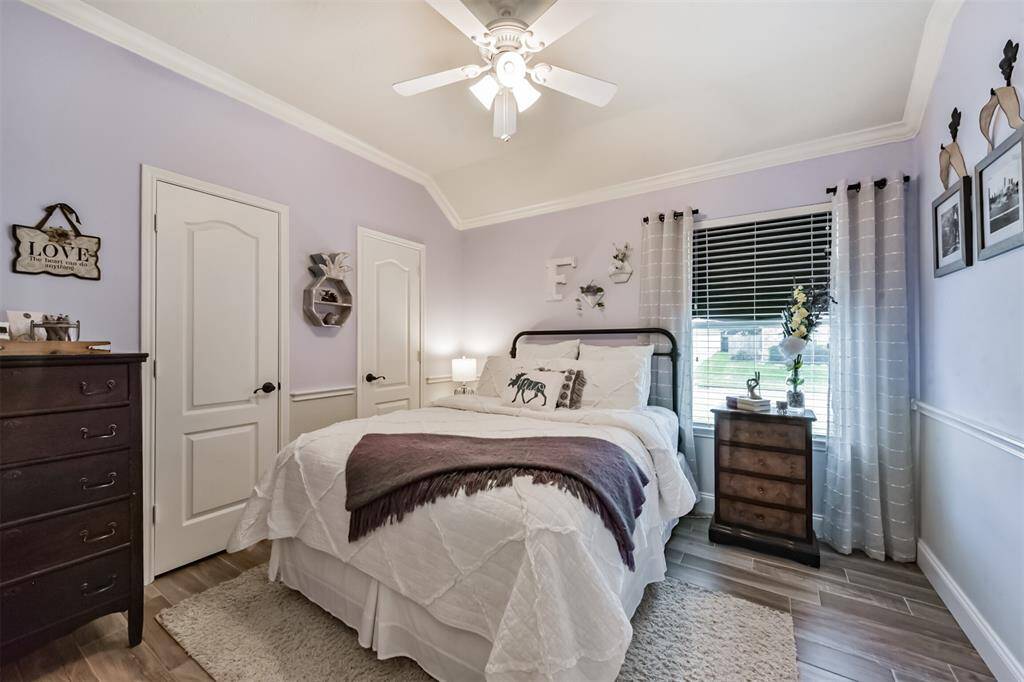 Bedroom number 2 features a ceiling fan, a stylish light fixture, and elegant chair molding, adding both comfort and charm.