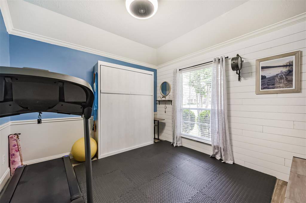 Flexible room featuring a pull-down bed and stylish shiplap wood accents.