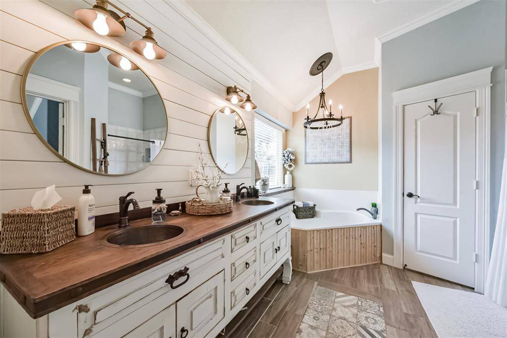 Custom double-sink vanity paired with a stylish wood-accented bathtub.