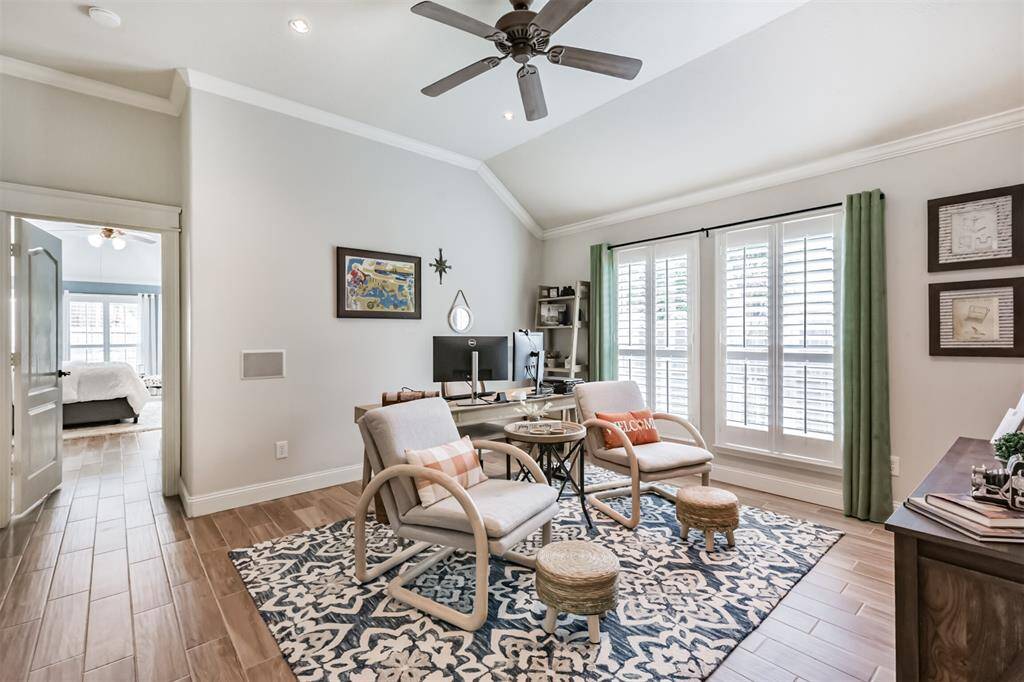The media room features elegant plantation shutters, a ceiling fan, and sophisticated accent lighting.