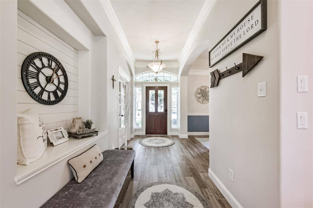 Elegant foyer featuring a recessed architectural wall and intricate triple crown molding.