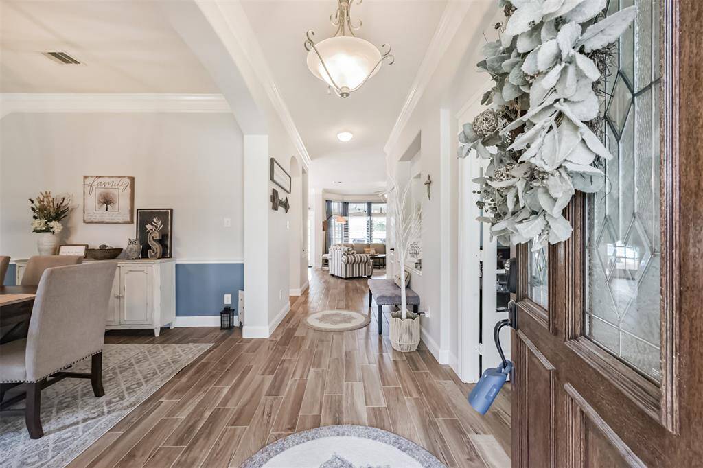 An inviting entrance featuring elegant ceramic tile flooring with a rich wood-look finish.