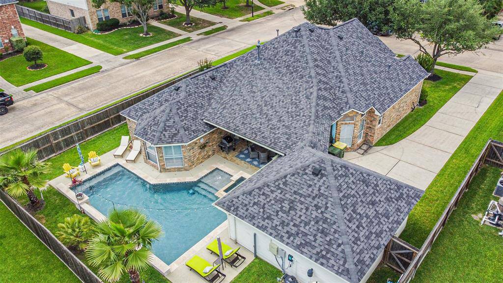 A stunning aerial view showcasing a home, complete with a luxurious swimming pool and spa.
