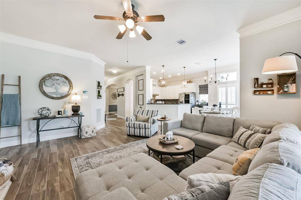 A family room featuring a ceiling fan with an integrated light fixture.