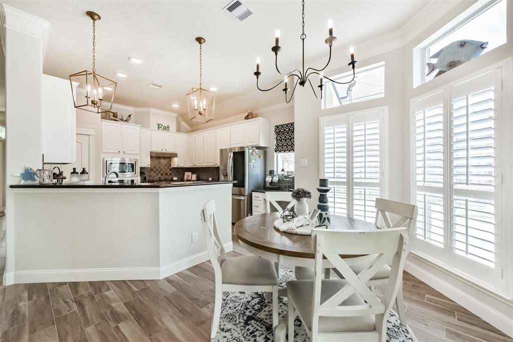 A breakfast room featuring elegant designer light fixtures and a stylish breakfast bar.