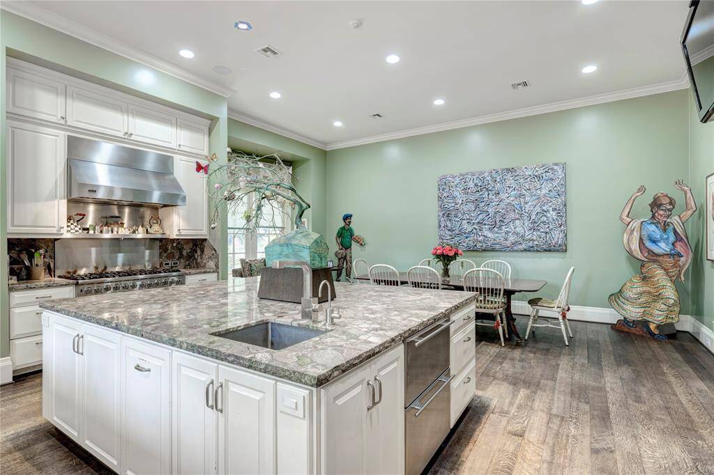 The centerpiece of this kitchen is the impressive oversized island, designed with a convenient veggie sink, stylish beverage drawers, and abundant storage space, making it the perfect hub for cooking and entertaining.