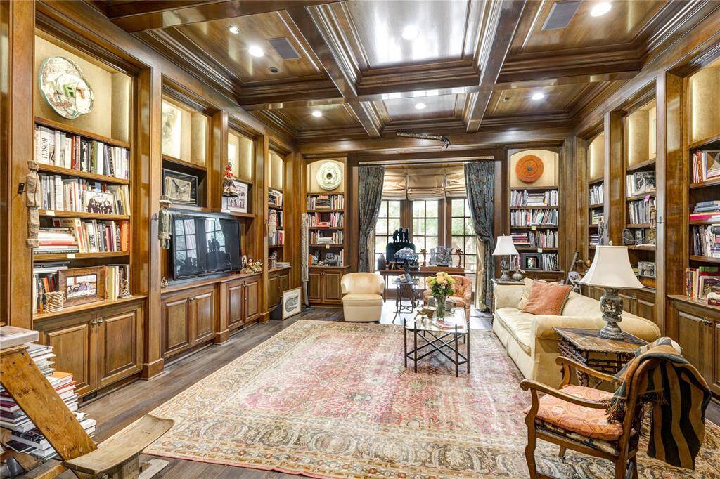 Tucked away off the Grand Hallway, this handsome room offers a study of sorts, or den. It features stained wood work, treated boxed ceilings, and the room is surrounded by bookshelves. French doors lead to the covered patio. Room dimensions are 19'x 17'.