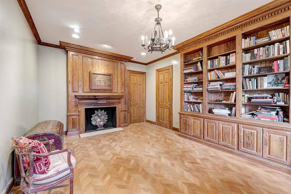 Bedroom three is currently being used as a study. It offers a full bathroom, walk-in closet, leathered chevron flooring, a "Pecky Cypress" reclaimed bookcase, mantle surround, and a mock fireplace.