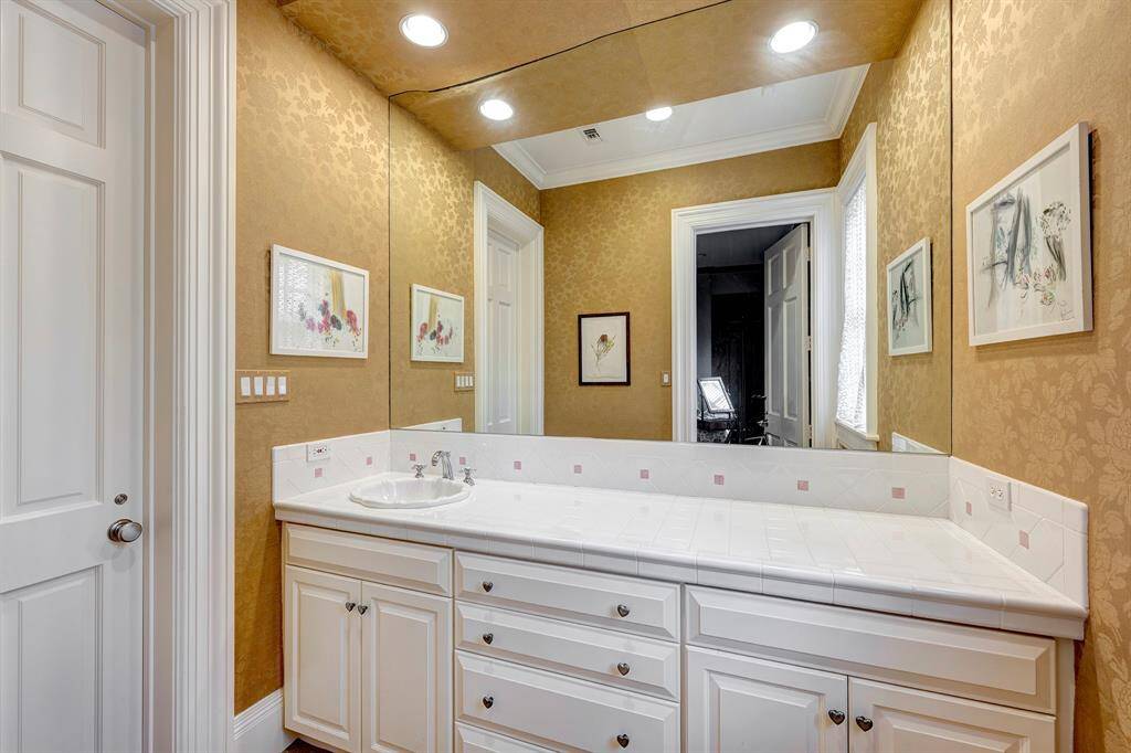 One of the secondary bathrooms with tub/shower, tiled surrounds and large vanity areas with drop in bowls.