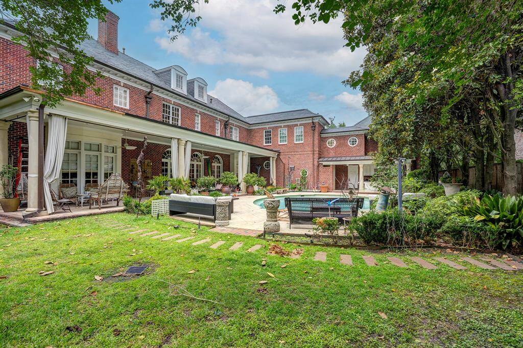 The brick exterior and slate roof give this stately home a traditional feel. On the back of the house, there is a large, covered porch that spans 12' x 60'. The porch has multiple sitting areas and would be the perfect place to entertain guests. Copper gutters, which really complement the overall style.