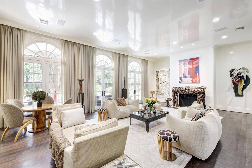 Step into a stunning family room adorned with a sleek lacquer finish on both the ceiling and walls. This inviting space boasts elegant French doors that open seamlessly along the expansive glass back wall, allowing natural light to flood in. The centerpiece of this room is a captivating wood-burning fireplace, perfect for cozy gatherings and creating lasting memories.