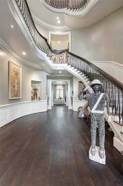 Step into the stunning foyer and be captivated by the exquisite Ed Wilson custom-designed wrought iron railing, elegantly topped with a rich oak cap. The magnificent staircase not only draws the eye but also offers breathtaking tiered views leading up to the third floor, creating an unforgettable first impression.