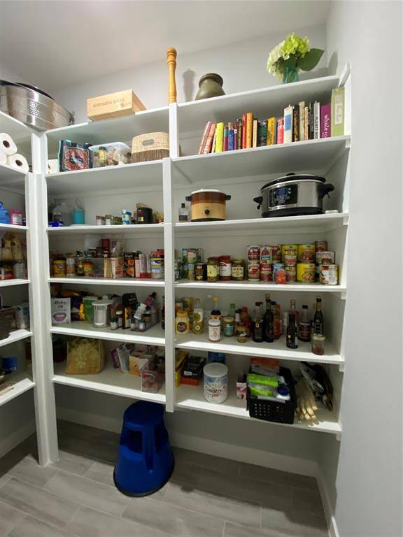 This walk-in pantry is so large it takes 2 photos to see it all! Plenty of storage for food, cookbooks, appliances, supplies, etc.
