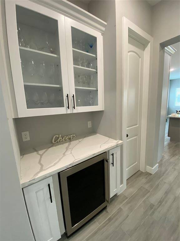 Beautiful wine bar/butlers pantry offers display cabinets for your best serving ware, 42-bottle Electrolux wine frig and lower cabinets for liquor and accessories.