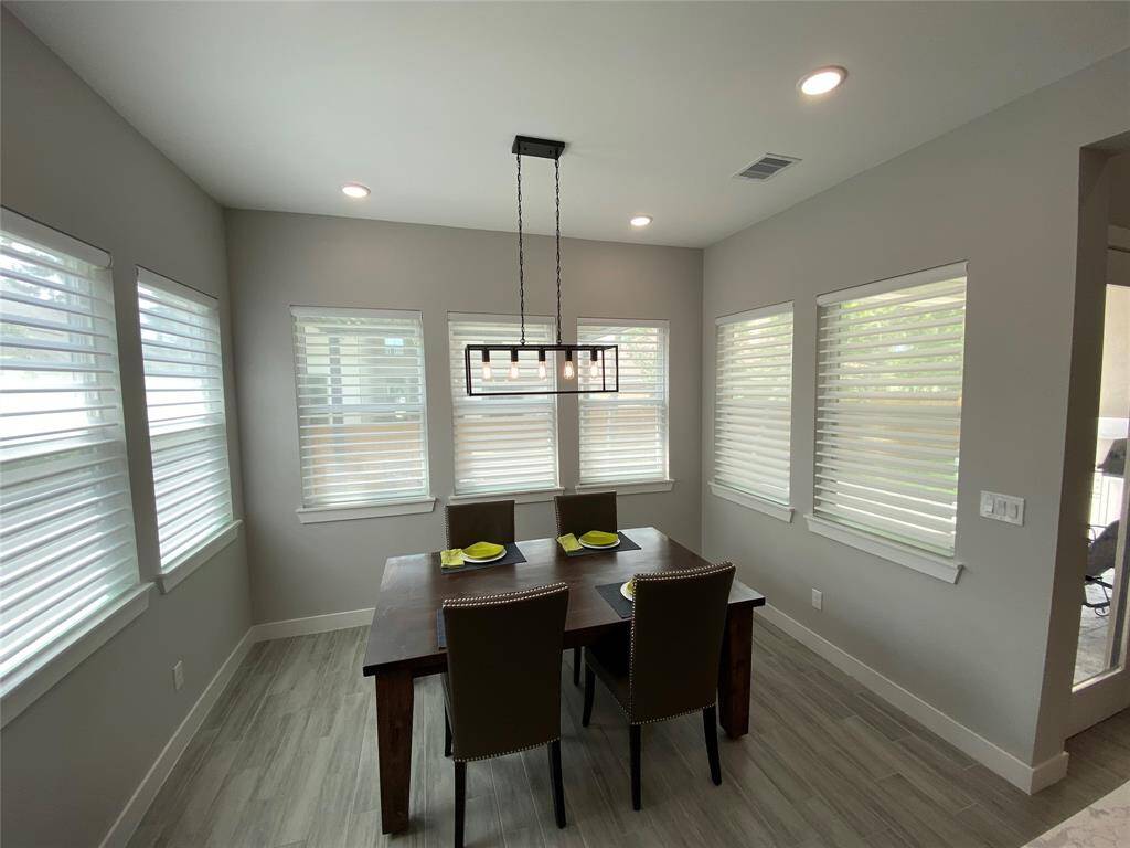 Light and bright dining area with programmable sheer shades and lighting - ready to set to your schedule. Program shades independently or as a group.