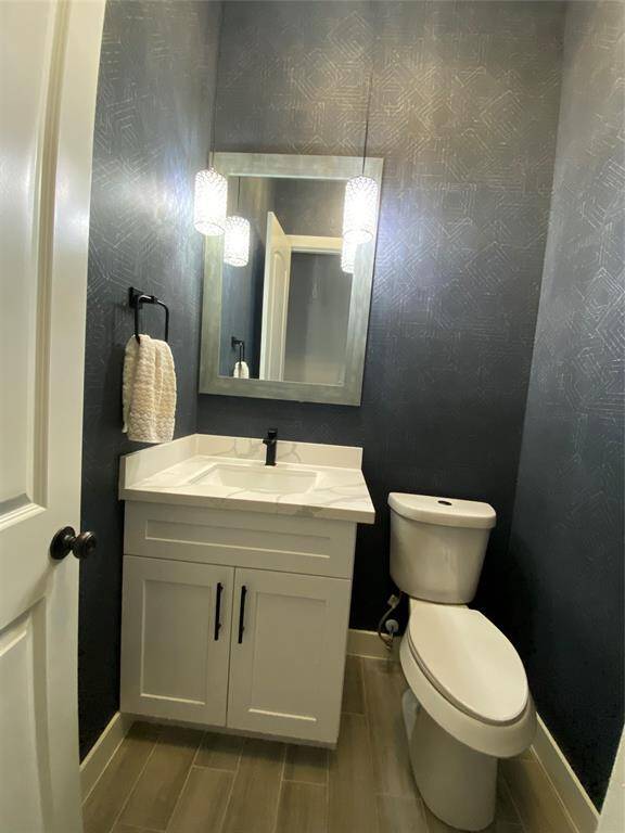 The powder room has been upgraded with wallpaper and crystal chandeliers