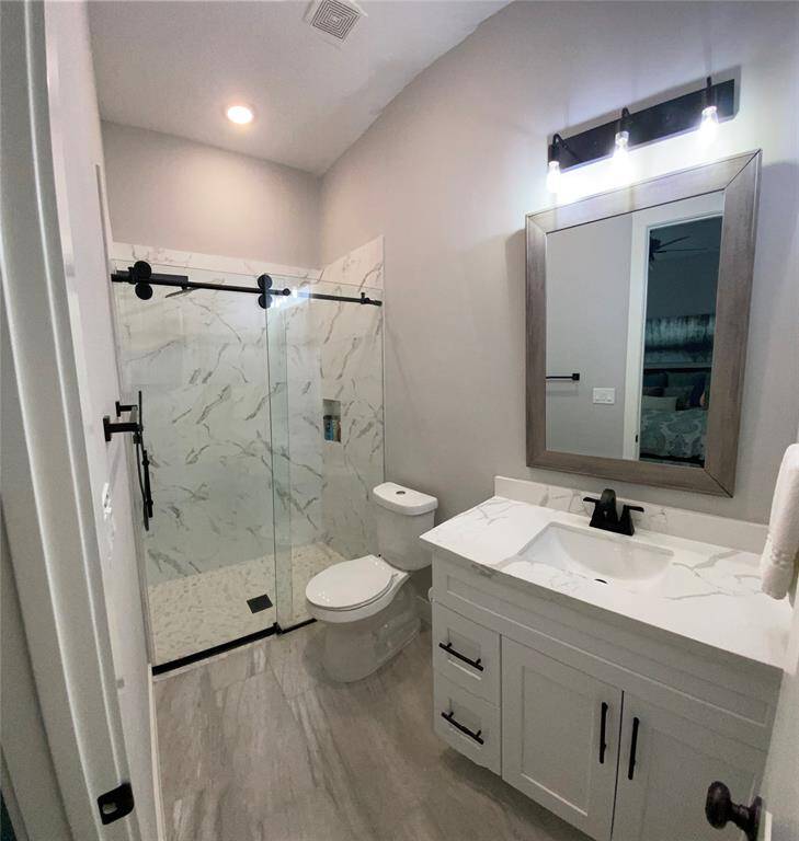 En-suite bathroom #2 offers rain shower head, hand held sprayer and modern rolling doors on the shower enclosure