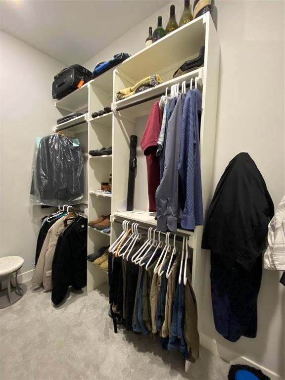Primary walk-in closet for HIM offers very efficient storage. Photo 1