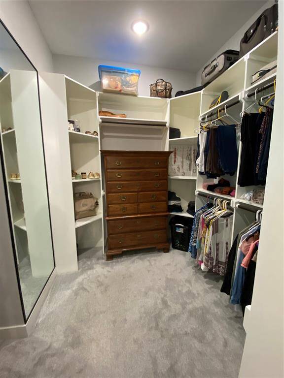 Primary closet for HER photo #2 - see the large storage cubbies.  One is even customized for jewelry display/storage.