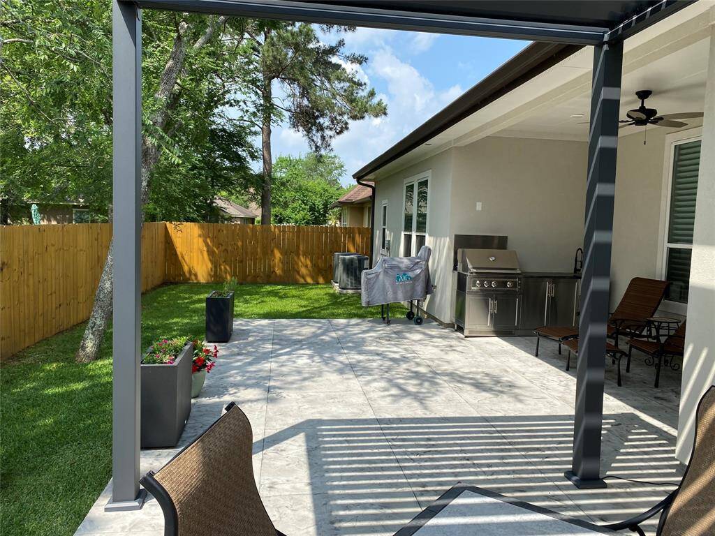 Extended patio with privacy fence, modern planters,remote controlled pergola and outdoor kitchen