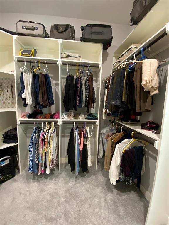 Primary closet for HER photo #3. Even room for a comfy dressing stool in the center
