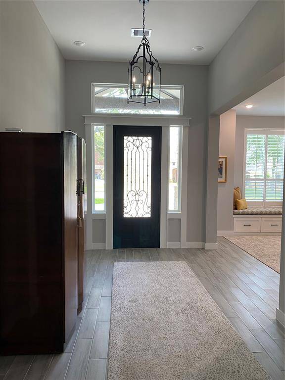 Foyer features a beautiful iron front door with transom windows providing great natural light. The foyer lights are programmable and dimmable.