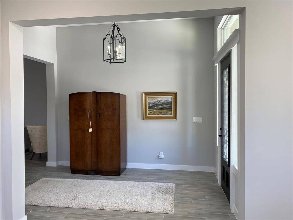 The large foyer with high ceiling and neutral colors is very welcoming. Custom rugs are included.