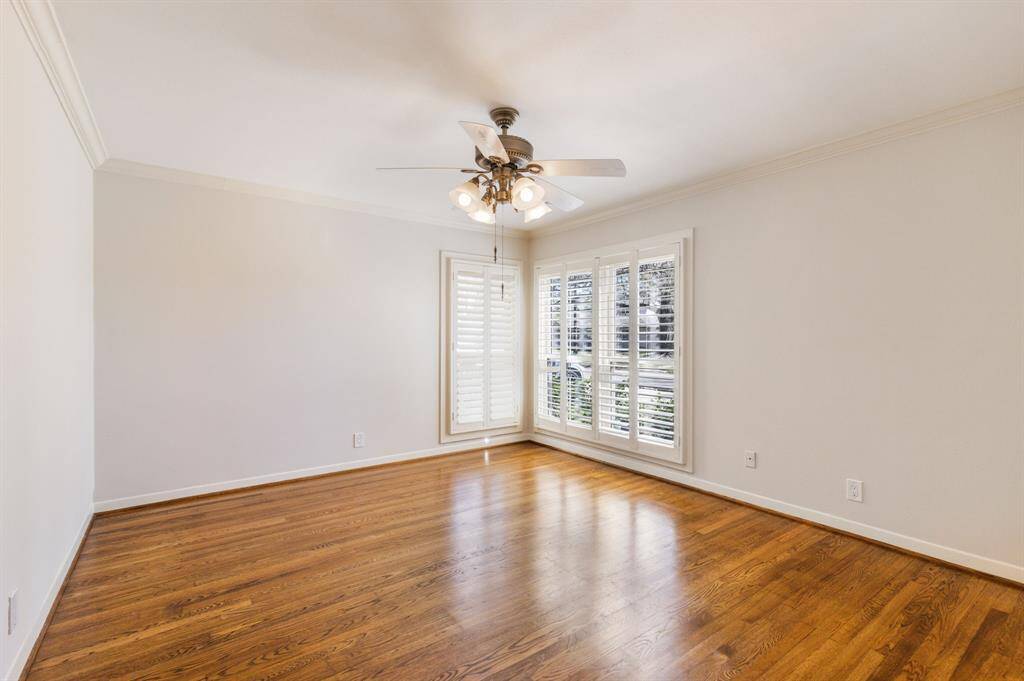 One of the three generously sized secondary rooms, this bedroom features windows positioned adjacently, allowing natural light to fill the space from both directions.