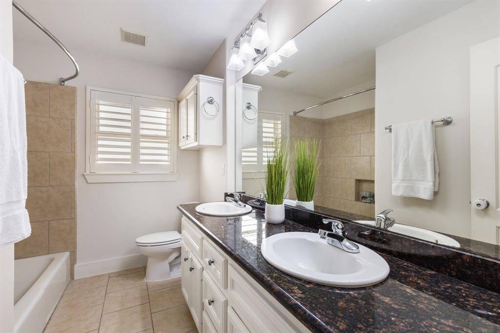 This secondary bathroom (which is one of two full baths inside property) is a standout, featuring double sinks for added convenience, along with ample storage space and high-end finishes. The third bathroom is the pool bathroom outside which enters from right side of garage next to the pool.