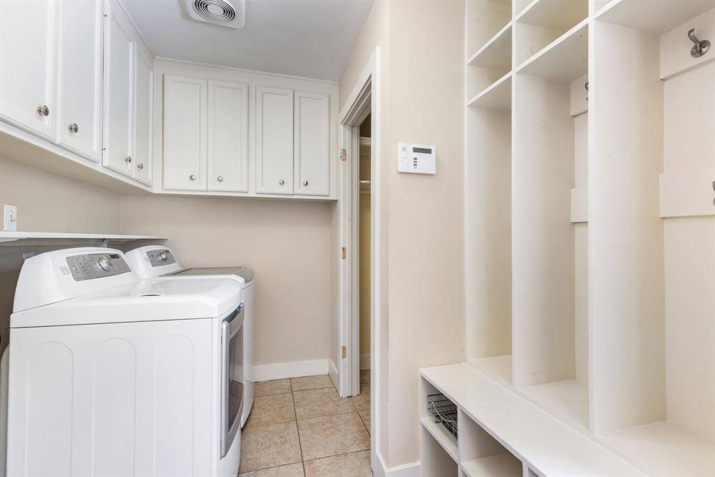 This spacious laundry room also includes a mudroom, offering plenty of cabinet space and added convenience.