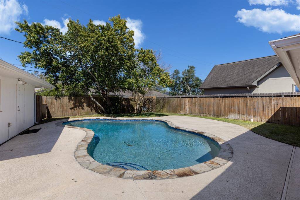 A couple of trees in the backyard provide a lovely shaded area, while a convenient sail shade can be set up over the pool, connecting to the tree, house, and garage for added comfort.
