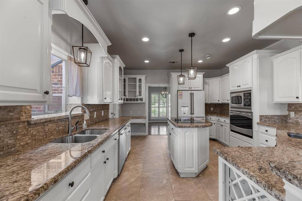 Additional kitchen highlights include a built-in oven with a microwave above and a rare yet practical feature—two sinks, including a dedicated prep sink for added convenience during meal prep and entertaining.