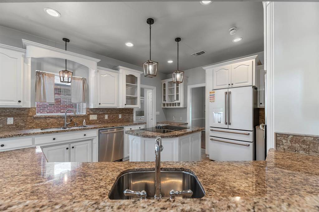 The prep sink is thoughtfully positioned beneath the expansive breakfast bar, making it easy to multitask while staying connected with family or guests.