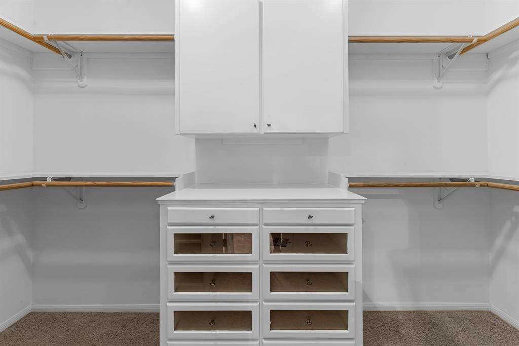 Wow! This impressive walk-in closet boasts shelving and hanging racks along the perimeter, plus a built-in cabinet with drawers—offering abundant space and thoughtful organization for your wardrobe.